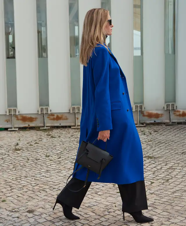 Woman wearing a blue coat walking outdoors